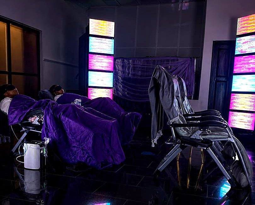 The EESystem room at JOES Energy House: recliners under purple light beside the glowing screens